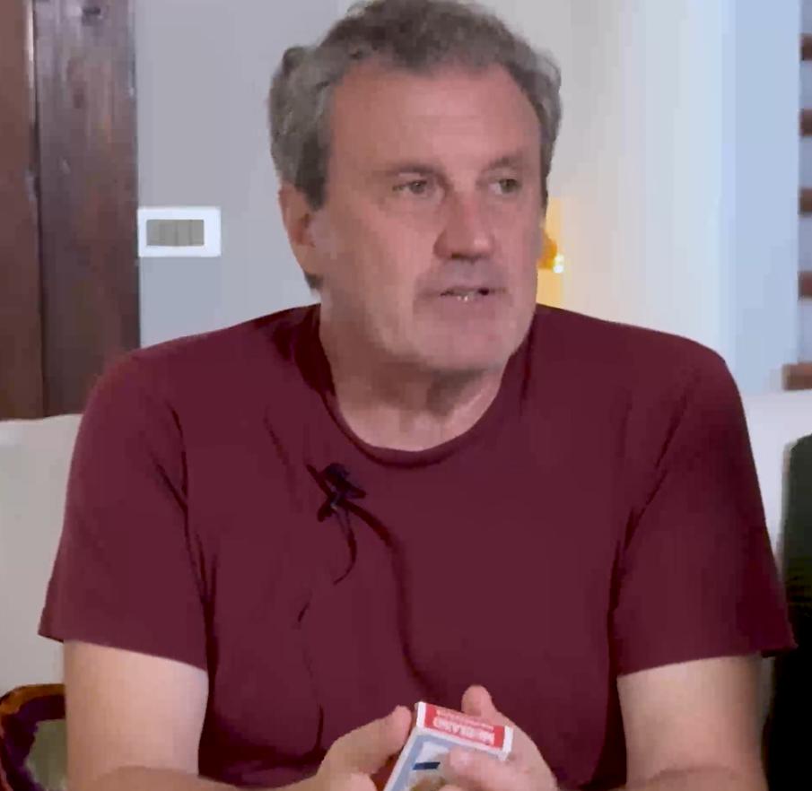 Antonio Manzini con un mazzo di carte napoletane in mano durante l'intervista su I tramezzini di Rocco Schiavone